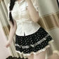 Mirror view of a model wearing the Dotted Doll Lace Skort with a fitted white blouse.