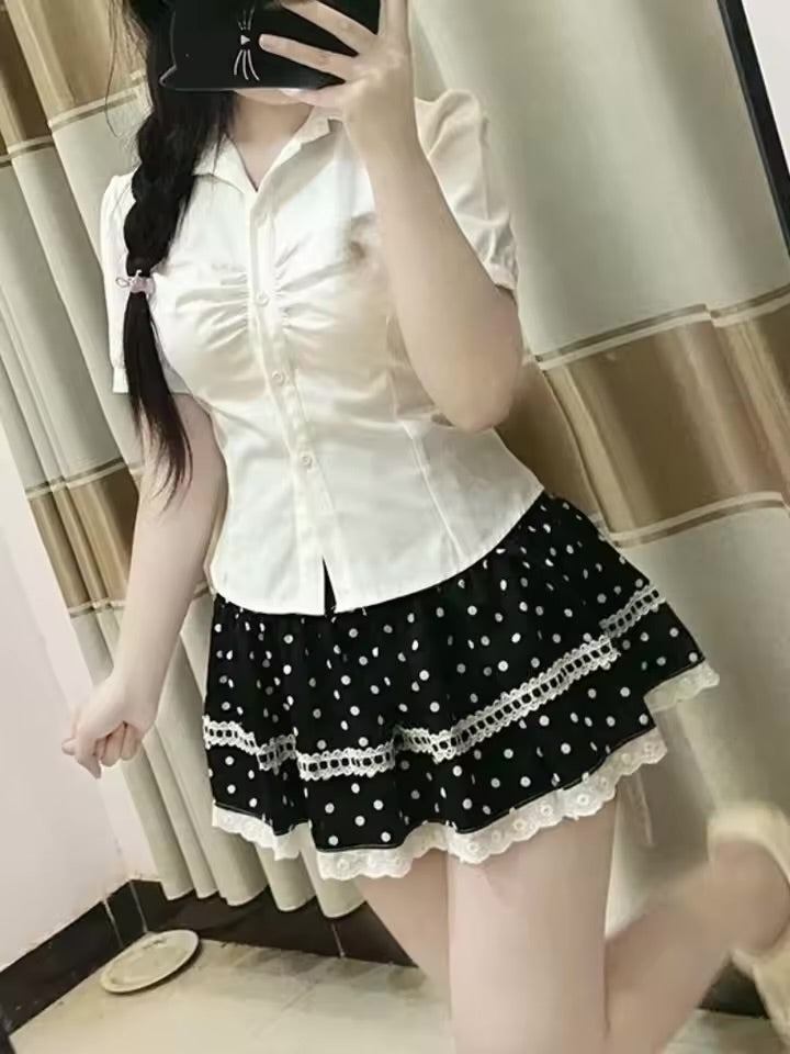 Mirror view of a model wearing the Dotted Doll Lace Skort with a fitted white blouse.