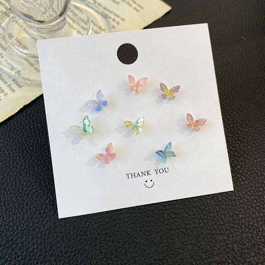 Flat lay of the full Dreamlit Butterfly Stud Earrings multi-set on thank-you card