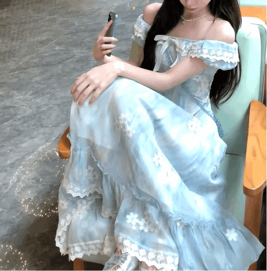 Model sitting on a chair with her feet on the seat wearing the midi version of the Ethereal Flower Princess Dress.