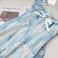A close-up on the flat lay of the mini Ethereal Flower Princess Dress, showcasing its bow detailing and flower embellishments.
