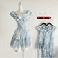 The mini Ethereal Flower Princess Dress on a mannequin, with the mini and midi versions of the dress hanging on the wall behind it.