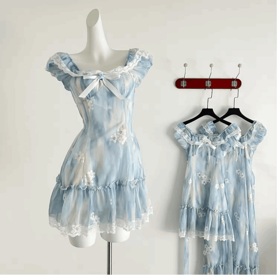 The mini Ethereal Flower Princess Dress on a mannequin, with the mini and midi versions of the dress hanging on the wall behind it.