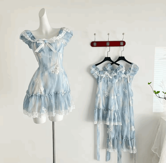 The mini Ethereal Flower Princess Dress on a mannequin, with the full view of the mini and midi versions of the dress hanging on the wall behind it.