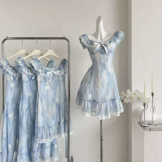 The mini Ethereal Flower Princess Dress on a mannequin next to a rack with the mini and midi versions of the dress hanging on it.