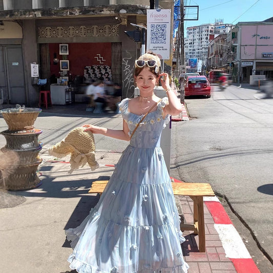 Model wearing the Ethereal Flower Princess Heavenly Bloom Midi Dress in light blue outdoors with daisy-trimmed neckline and 3D floral appliqués.