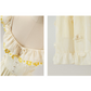Close-up of details on the Ethereal Flower Princess Heavenly Bloom Midi Dress in light yellow, like the daisy embroidered neckline and ruffled hemline.