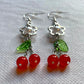 Angled view of Fairy Cherry Pearl Earrings showing glossy cherry charm details