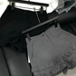 Frill Rush Layered Shorts in black and gray displayed on a hanger and laid on a couch