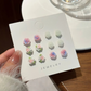 Set of six pastel rose and flower stud earrings displayed on a white jewelry card from the Garden Party Pastel Earrings.