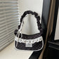The Lacy Dotling Purse, a black polka-dot lace-trimmed purse, displayed on a white windowsill.