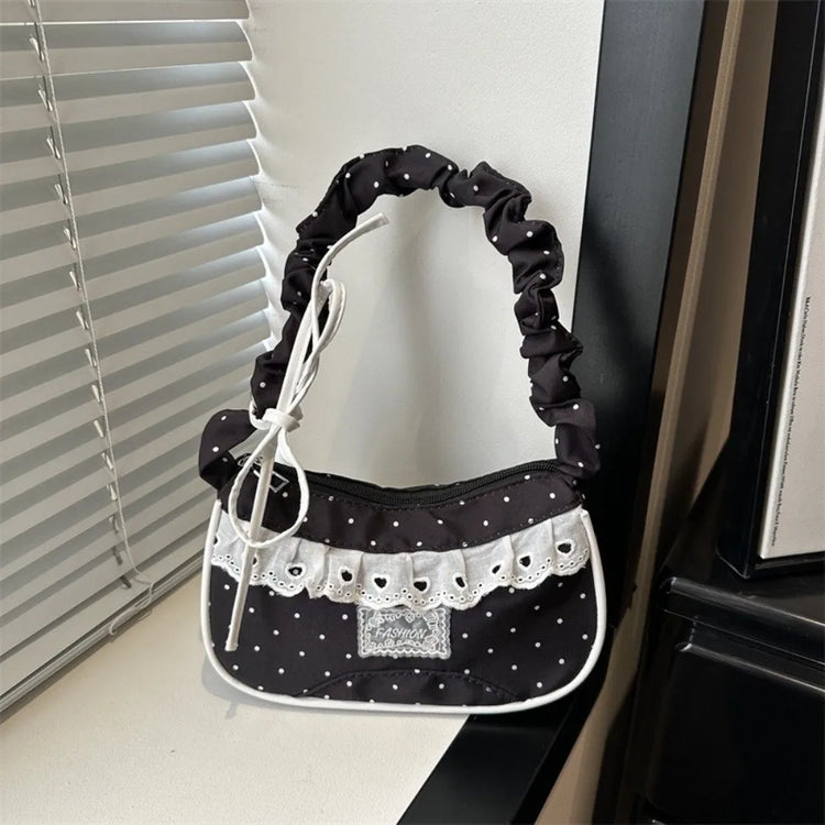 The Lacy Dotling Purse, a black polka-dot lace-trimmed purse, displayed on a white windowsill.