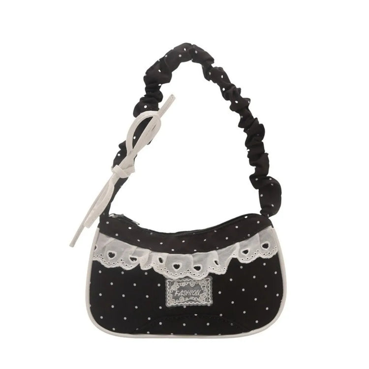 The Lacy Dotling Purse, a black polka-dot lace-trimmed purse, isolated by itself on a white background.
