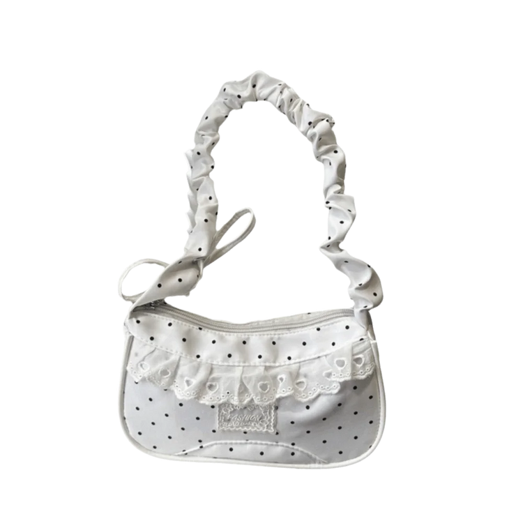 The Lacy Dotling Purse, a white polka-dot lace-trimmed purse, isolated by itself.