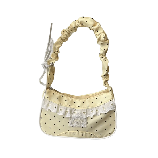 The Lacy Dotling Purse, a yellow polka-dot lace-trimmed purse, isolated by itself.