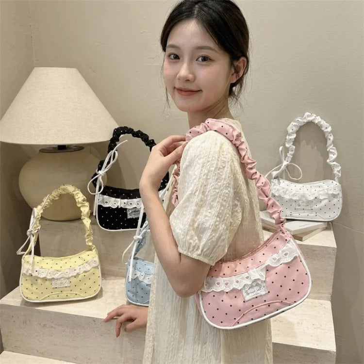 Model holding the Lacy Dotling Purse, a pink polka-dot lace-trimmed purse, with yellow, blue, white, and black color options behind her.