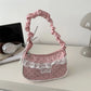 The Lacy Dotling Purse, a pink, polka-dot, lace-trimmed purse, displayed on a white desk.