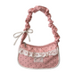 The Lacy Dotling Purse, a pink polka-dot lace purse, on a white background.