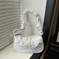 The Lacy Dotling Purse, a white polka-dot lace-trimmed purse, displayed on a white windowsill.
