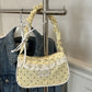 The Lacy Dotling Purse, a yellow polka-dot lace-trimmed purse, hanging from a rack.
