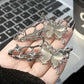 Hand holding Liquid Metal Butterfly Hair Clips showing its detailed silver design.