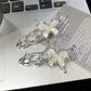 Two silver Liquid Metal Butterfly Hair Clips resting on a laptop keyboard.