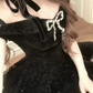 Close-up of the Midnight Gala Bow Dress, emphasizing the jeweled bow detail on black velvet off-shoulder dress.
