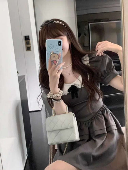 Mirror selfie of model in the Midnight Mourning Baby Doll Dress, styled with pearl headband and accessories