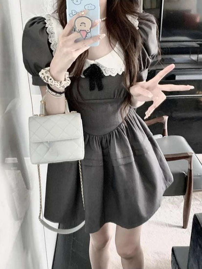 Model takes a playful peace sign selfie in the Midnight Mourning Baby Doll Dress, showing collar and puff sleeves