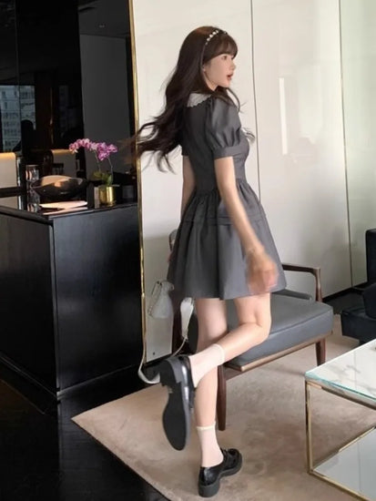 Model walking away in the Midnight Mourning Baby Doll Dress, showing puff sleeves and flared silhouette