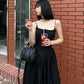 Close-up of the corset bodice of the Midnight Sonata Corset Dress with a black purse accessory.