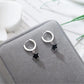 The Midnight Star Drop Earrings, black star drop earrings, arranged on a gray velvet jewelry box.