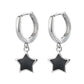Isolated pair of the Midnight Star Drop Earrings, silver hoop earrings with glossy black star charms.