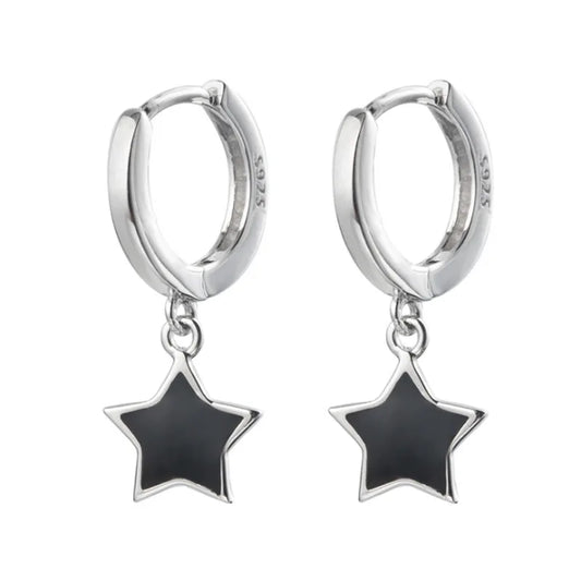 Isolated pair of the Midnight Star Drop Earrings, silver hoop earrings with glossy black star charms.