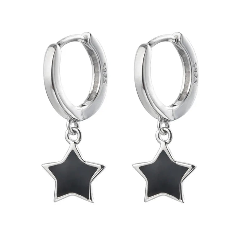Isolated pair of the Midnight Star Drop Earrings, silver hoop earrings with glossy black star charms.
