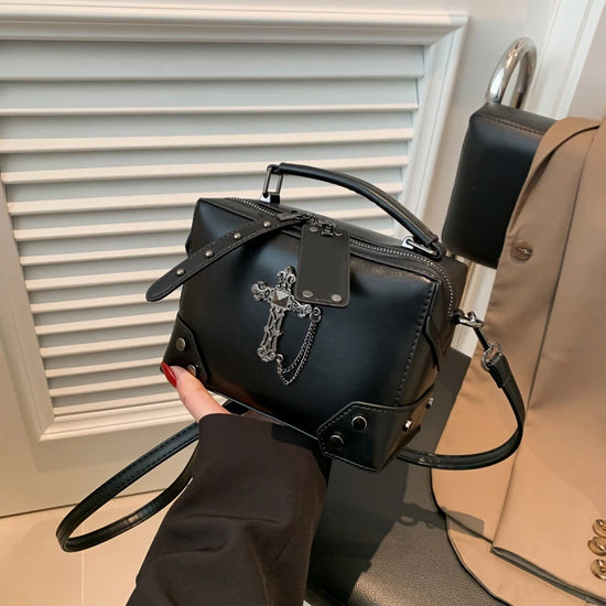 Handheld angled view of the Moonlit Mourning Crossbody with the cross design.