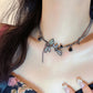 The Moonvine Dragonfly Necklace styled with a dark floral top, showcasing the delicate dragonfly details and smoky silver tones.