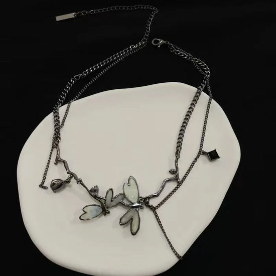 Dramatic product display of the Moonvine Dragonfly Necklace with layered chains, dragonfly-inspired details, and dark romantic styling.