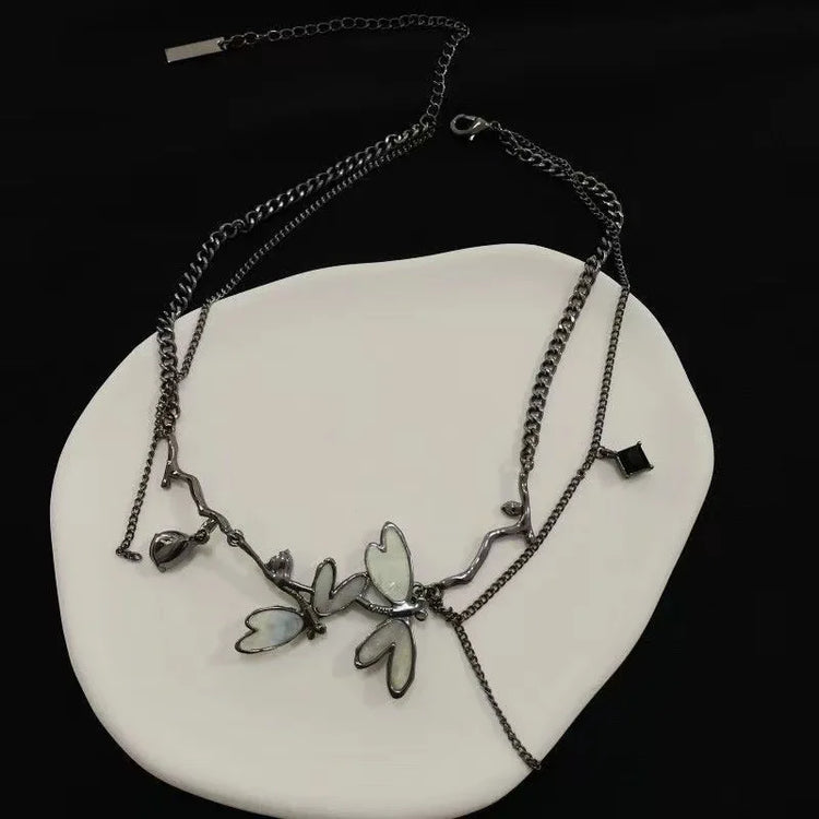 Dramatic product display of the Moonvine Dragonfly Necklace with layered chains, dragonfly-inspired details, and dark romantic styling.