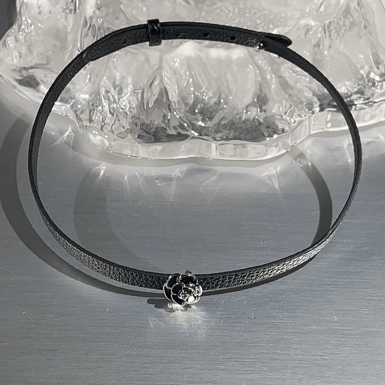 Black faux leather choker with rose centerpiece detail.