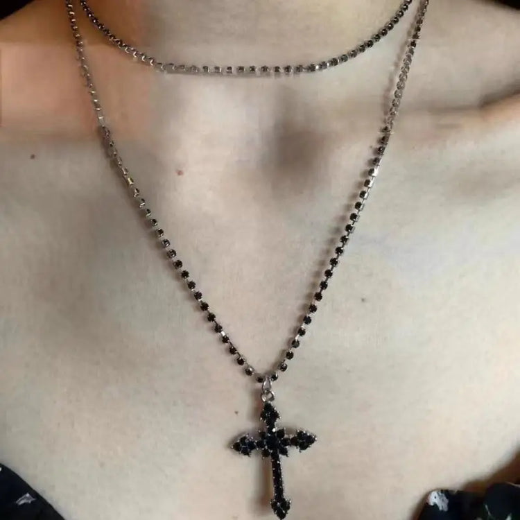 Close-up of the Obsidian Grace Layered Cross Necklace with black jeweled cross pendant on a layered chain.