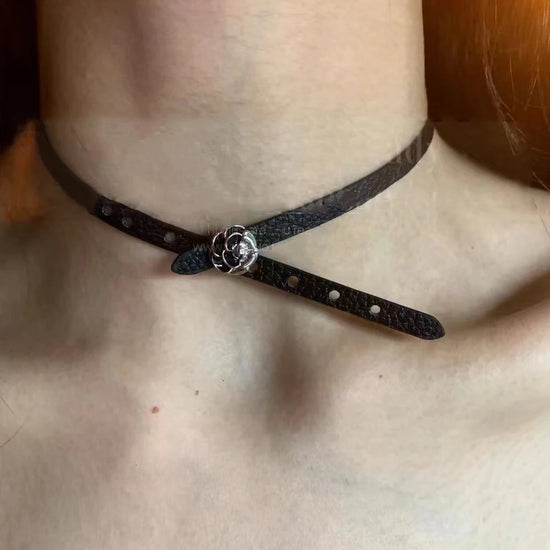 Black faux leather choker featuring a silver rose charm centerpiece.