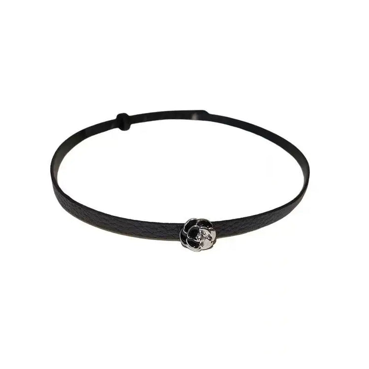 Flatlay of the Obsidian Grace Rose Choker with black strap and silver rose charm.