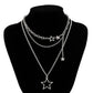The Orbit Dreams Necklace displayed on a black jewelry bust with layered star chain design
