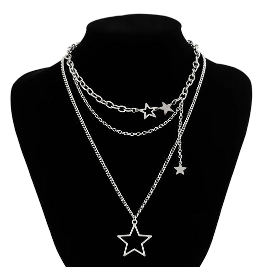 The Orbit Dreams Necklace displayed on a black jewelry bust with layered star chain design