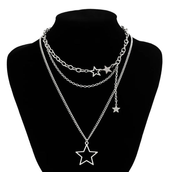 The Orbit Dreams Necklace displayed on a black jewelry bust with layered star chain design