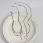 Orbit Dreams Necklace flat lay featuring silver layered chains and celestial star charms