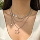 Close-up of the Orbit Dreams Necklace, showing layered silver chains and star pendants
