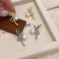 Gold and Silver Pearl Whim Bow Earrings displayed together in a box