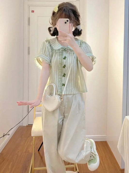 Model wearing Pistachio Ribbon Striped Blouse with wide-leg pants and heart bag
